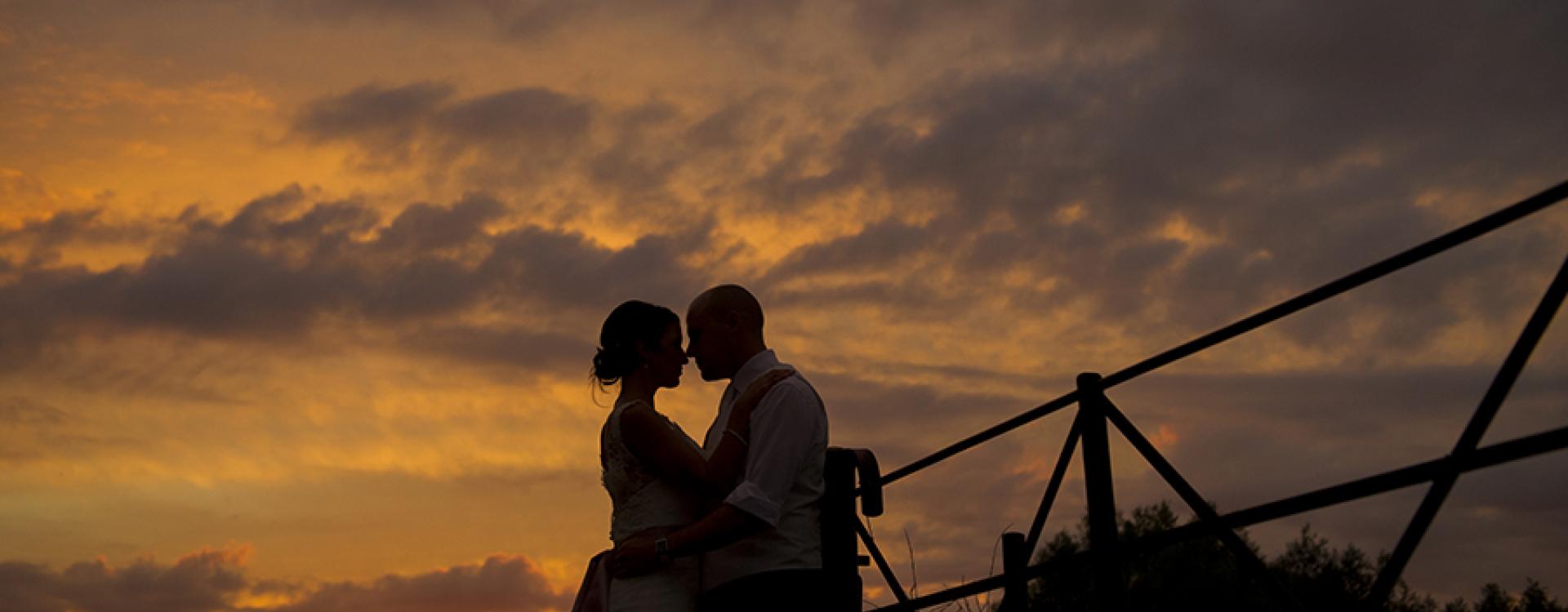 wedding couple silhouetted against sunset