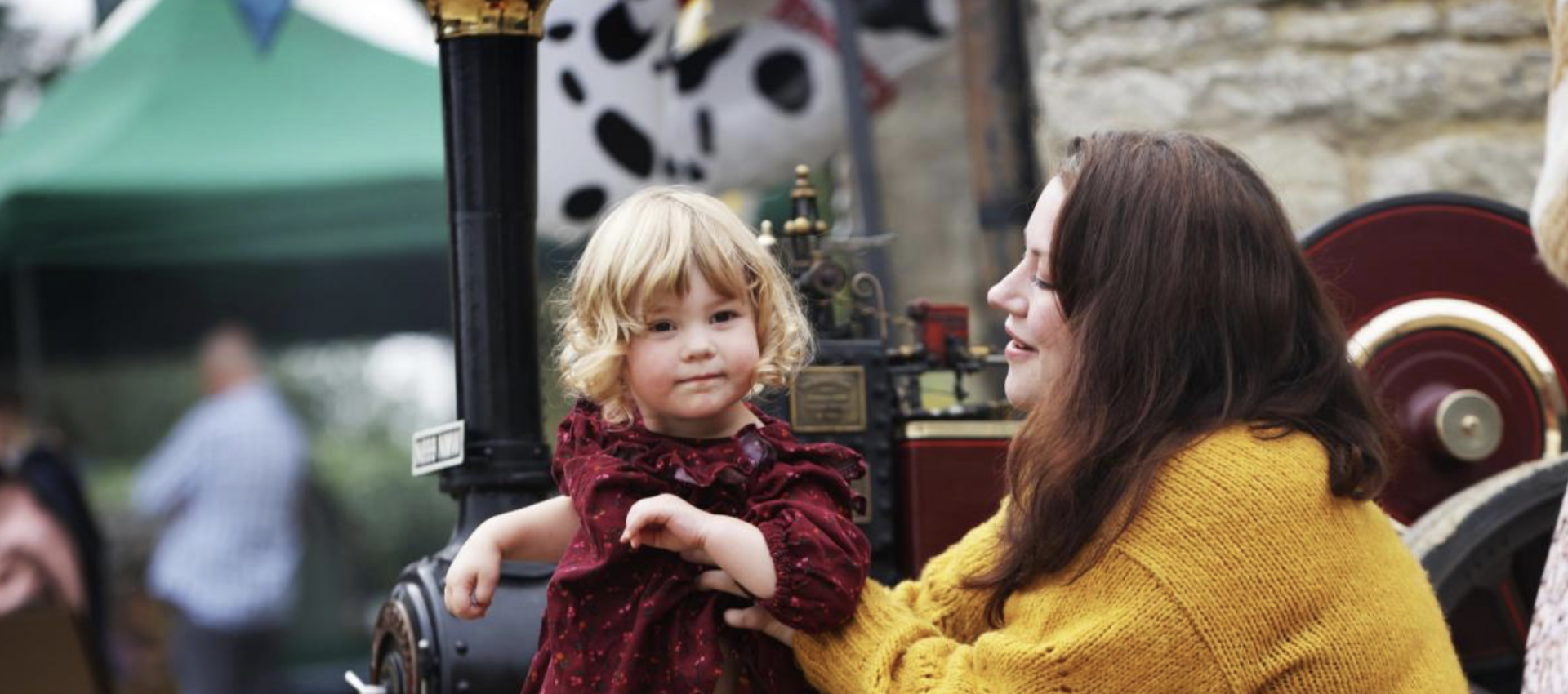 mother and child in autumnal colours by steam engine