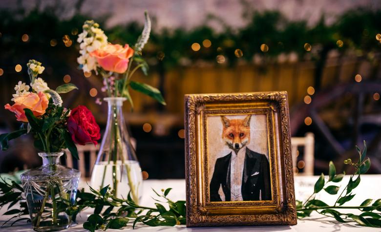 Wedding table laid with framed picture of a fox in suit 
